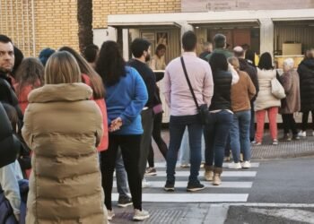Colas para comprar chocolate y buñuelos con el viento de protagonista en la plantà