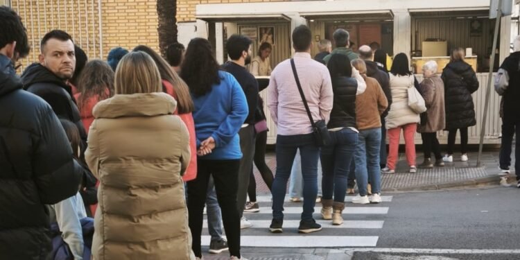 Colas para comprar chocolate y buñuelos con el viento de protagonista en la plantà