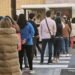 Colas para comprar chocolate y buñuelos con el viento de protagonista en la plantà